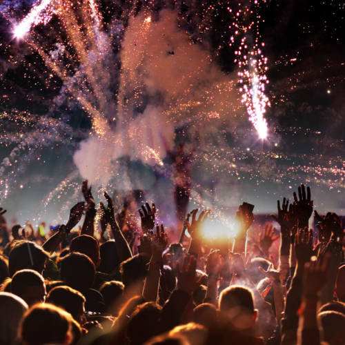 crowd with raised hands at concert festival banner