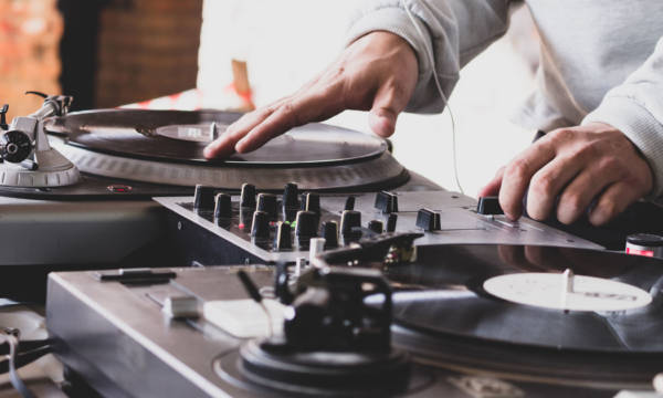 DJ playing music at a hip hop party. analog turntable, Dj uses turntable and mixer for scratching.