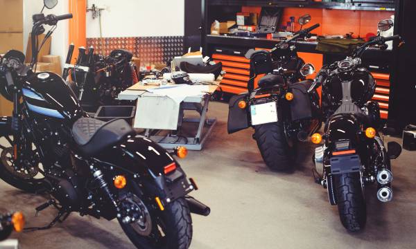 Many motorcycles on the floor with workshop tools, a modern garage, storage and repair. This bike will be perfect. repairing a motorcycle in a repair shop.